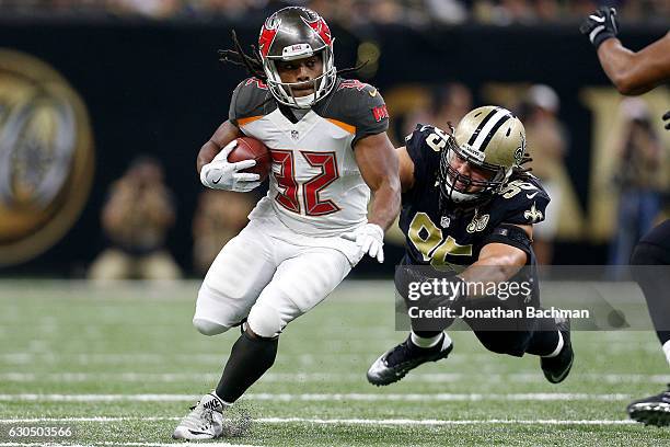 Jacquizz Rodgers of the Tampa Bay Buccaneers avoids a tackle by Tyeler Davison of the New Orleans Saints at the Mercedes-Benz Superdome on December...
