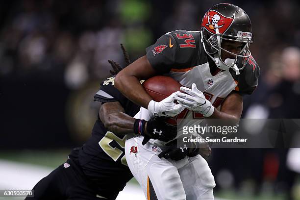 Charles Sims of the Tampa Bay Buccaneers is tackled by B.W. Webb of the New Orleans Saints at the Mercedes-Benz Superdome on December 24, 2016 in New...