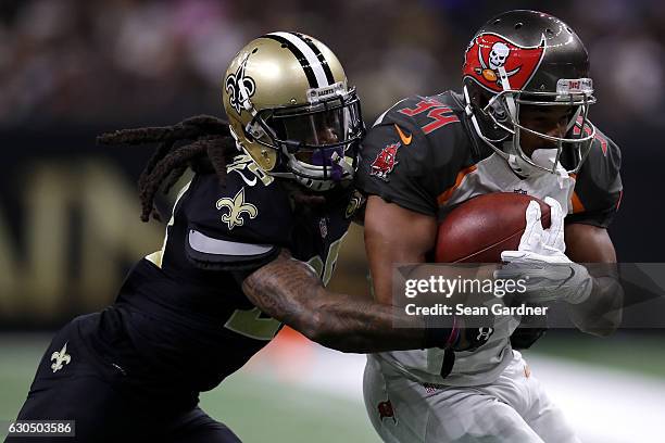 Charles Sims of the Tampa Bay Buccaneers is tackled by B.W. Webb of the New Orleans Saints at the Mercedes-Benz Superdome on December 24, 2016 in New...