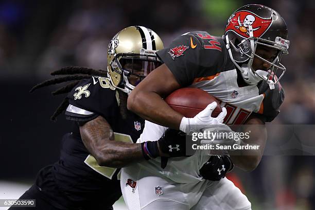 Charles Sims of the Tampa Bay Buccaneers is tackled by B.W. Webb of the New Orleans Saints at the Mercedes-Benz Superdome on December 24, 2016 in New...