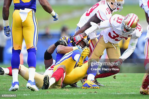 Todd Gurley of the Los Angeles Rams is tackled by Gerald Hodges and Rashard Robinson of the San Francisco 49ers during the first half of their game...