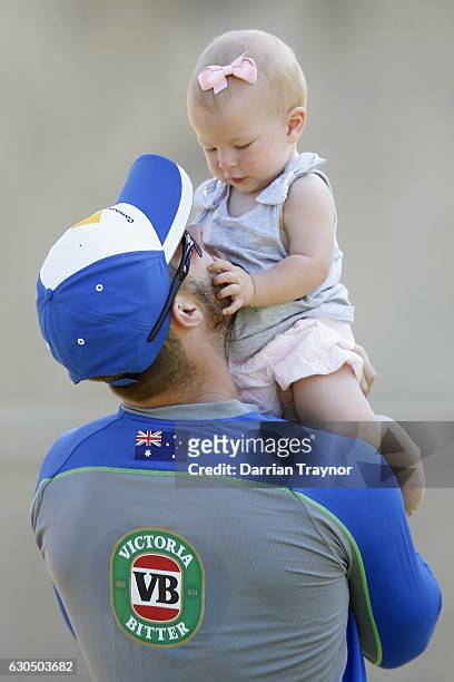 Matthew Wade takes a break with his child Winter during an Australian nets session on December 25, 2016 in Melbourne, Australia.