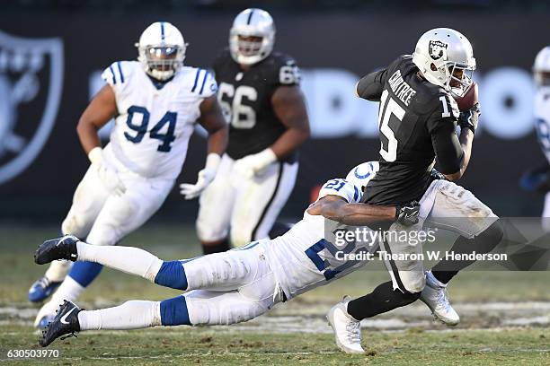 Michael Crabtree of the Oakland Raiders is tackled by Vontae Davis of the Indianapolis Colts during their NFL game at Oakland Alameda Coliseum on...