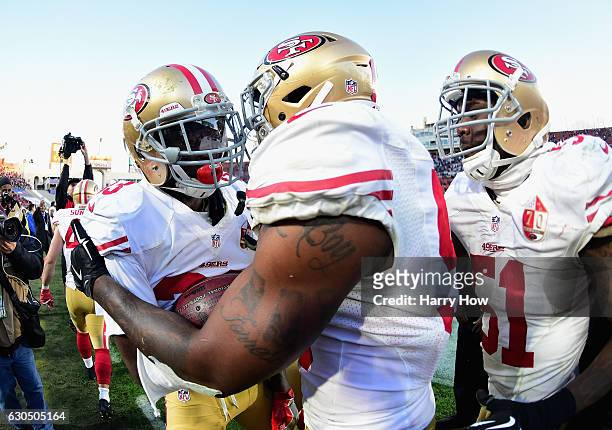 Rashard Robinson celebrates with Eli Harold of the San Francisco 49ers after defeating the Los Angeles Rams 22-21 at Los Angeles Memorial Coliseum on...