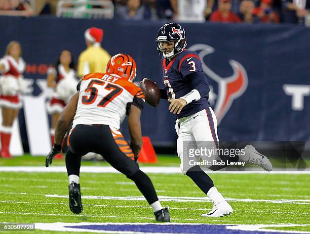 Tom Savage of the Houston Texans runs out of the pocket as Vincent Rey of the Cincinnati Bengals pursues at NRG Stadium on December 24, 2016 in...