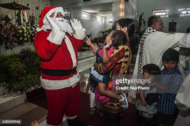 Santa Claus greets childrens when attend mass in celebration of Christmas in Sacred Heart of Jesus Catholic Church in Yogyakarta, Indonesia, on...