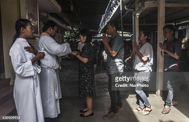 Christian people received the host when attend mass in celebration of Christmas in Sacred Heart of Jesus Catholic Church in Yogyakarta, Indonesia, on...