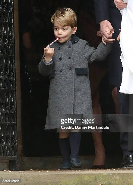 Prince George of Cambridge licks a candy cane at Church on Christmas Day on December 25, 2016 in Bucklebury, Berkshire.