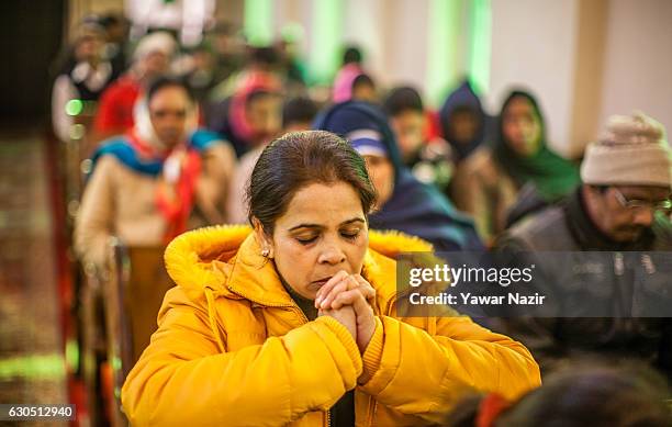 Christians attend Christmas mass inside the Holy Family Catholic Church during Christmas on December 25, 2016 in Srinagar, the summer capital of...
