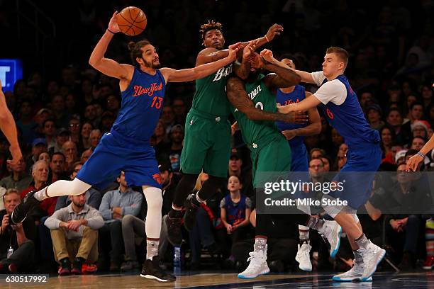 Joakim Noah and Kristaps Porzingis of the New York Knicks pursue the loose ball against Marcus Smart and Amir Johnson of the Boston Celtics at...