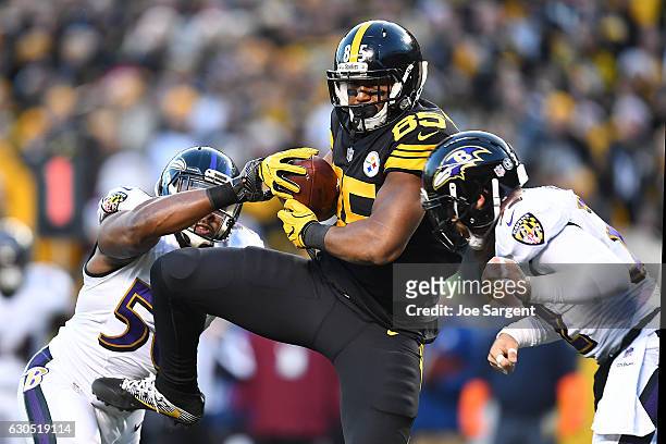 Xavier Grimble of the Pittsburgh Steelers catches a 20 yard pass from Ben Roethlisberger in between Albert McClellan and Eric Weddle of the Baltimore...