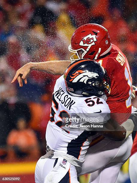 Quarterback Alex Smith of the Kansas City Chiefs is hit by inside linebacker Corey Nelson of the Denver Broncos during the game at Arrowhead Stadium...
