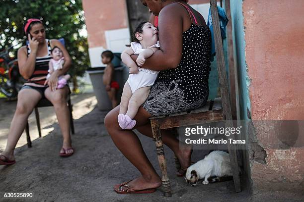 Family members hold twins Eloisa ( and Eloa, both 8 months old and both born with microcephaly, during a Christmas gathering at the home of the...