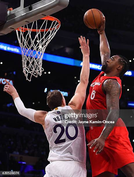 DeAndre Jordan of the Los Angeles Clippers dunks over Timofey Mozgov of the Los Angeles Lakers for the first basket of the game at Staples Center on...