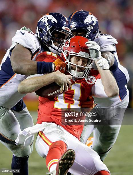 Quarterback Alex Smith of the Kansas City Chiefs is tackled by inside linebacker Todd Davis and inside linebacker Corey Nelson of the Denver Broncos...