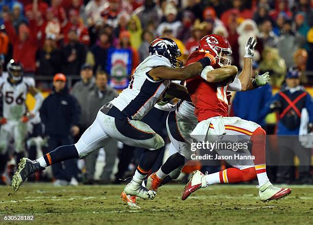 Quarterback Alex Smith of the Kansas City Chiefs is tackled by inside linebacker Todd Davis and inside linebacker Corey Nelson of the Denver Broncos...