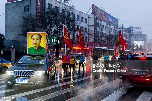 People parade on a street to mark the 123rd birth anniversary of Chairman Mao on December 26, 2016 in Huaxian, China. PHOTOGRAPH BY Feature China /