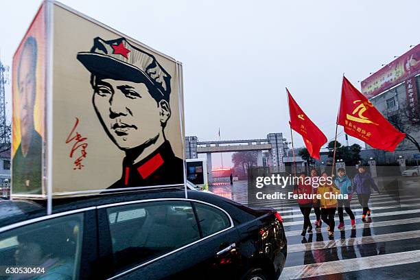 People parade on a street to mark the 123rd birth anniversary of Chairman Mao on December 26, 2016 in Huaxian, China. PHOTOGRAPH BY Feature China /