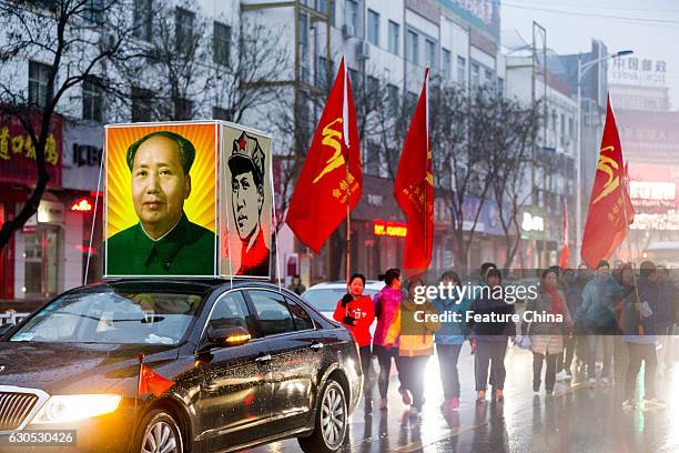 People parade on a street to mark the 123rd birth anniversary of Chairman Mao on December 26, 2016 in Huaxian, China. PHOTOGRAPH BY Feature China /