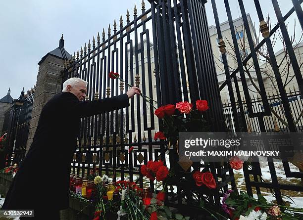 People lay flowers at the gate of the Russian embassy in Minsk, on December 26 a day after a military plane carrying 92 people, including dozens of...