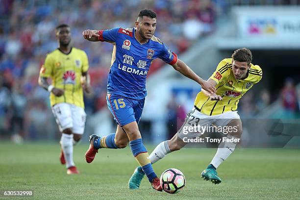 Andrew Nabbout of the Jets contests the ball with Matthew Ridenton of the Phoenix during the round 12 A-League match between the Newcastle Jets and...