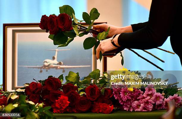 People lay flowers at the gate of the Russian embassy in Minsk, on December 26 a day after a military plane carrying 92 people, including dozens of...