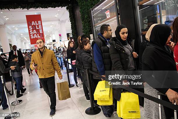 Customers queue outside a designer stall during the Boxing Day sale at Selfridges on December 26, 2016 in London, England. Boxing Day is...