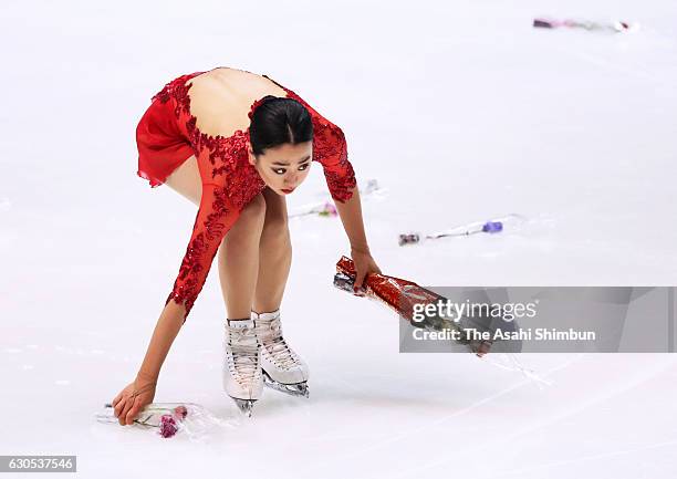 Mao Asada picks up flower bouquets after competing in the Women's Singles Free Skating during day four of the 85th All Japan Figure Skating...