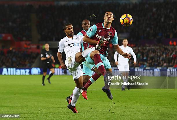 Wayne Routledge of Swansea City challenges for the ball with Winston Reid of West Ham United during the Premier League match between Swansea City and...