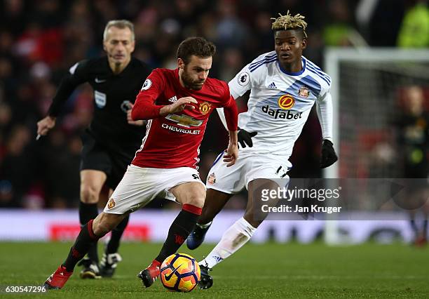 Juan Mata of Manchester United is challenged by Dider Ndong of Sunderland during the Premier League match between Manchester United and Sunderland at...