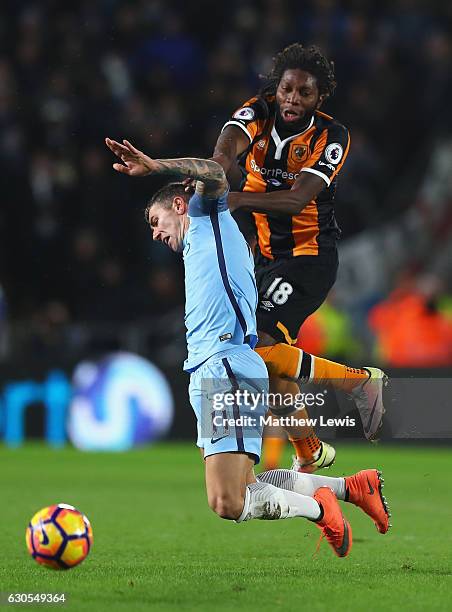 Dieumerci Mbokani of Hull City challenges Aleksandar Kolorov of Manchester City during the Premier League match between Hull City and Manchester City...