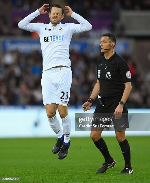 Gylfi Sigurdsson of Swansea City reacts after his free kick is saved as referee Andre Marriner looks on during the Premier League match between...