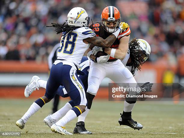 Tight end Gary Barnidge of the Cleveland Browns carries the ball downfield as he is tackled by defensive back Trovon Reed and Dwight Lowery of the...