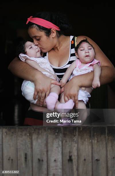 Mother Raquel Barbosa poses holding her twin daughters Eloisa and Eloa, both 8 months old and both born with microcephaly, on Christmas day during a...