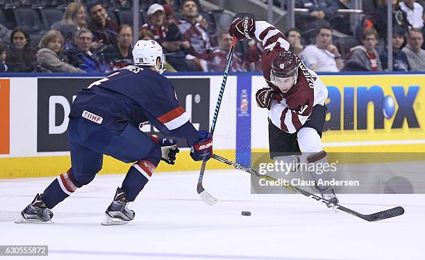 Caleb Jones of Team USA defends against Martins Dzierkals of Team Latvia during a 2017 IIHF World Junior Hockey Championship game at the Air Canada...