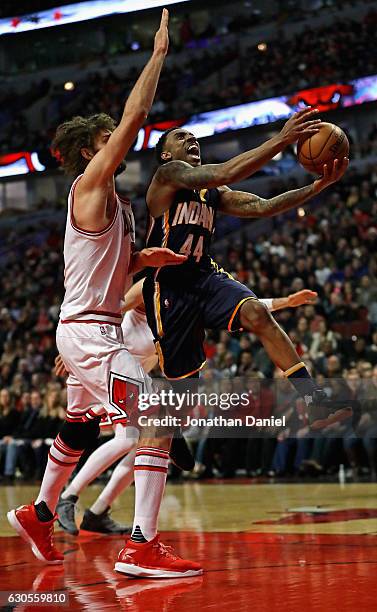 Jeff Teague of the Indiana Pacers drives past Robin Lopez of the Chicago Bulls at the United Center on December 26, 2016 in Chicago, Illinois.