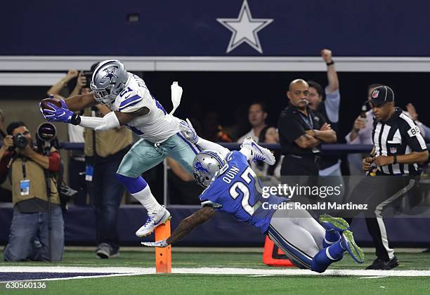 Ezekiel Elliott of the Dallas Cowboys dives across the goal line to score a touchdown as Glover Quin of the Detroit Lions defends during the first...