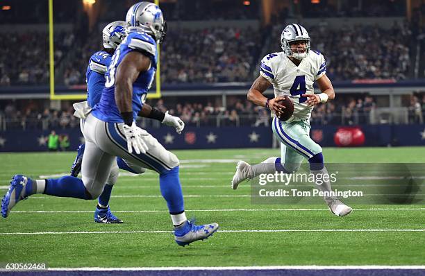 Dak Prescott of the Dallas Cowboys scrambles as Tahir Whitehead and Ezekiel Ansah of the Detroit Lions pursue during the second half at AT&T Stadium...