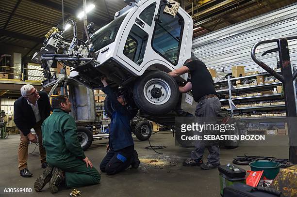 Men work on the LEV1200 electric washer at the Val air workshop on November 24, 2016 in La Cote. Mayor of Paris' determination to ban diesel from the...