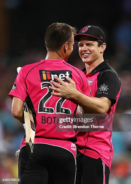 Johan Botha of the Sixers celebrates with a member of the Sixers staff after hitting the winning runs following the Big Bash League match between the...