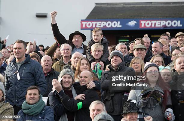 The crowd in grandstand and paddock cheer the horses running in first race during the 2016 Coral Welsh Grand National at Chepstow Racecourse on...
