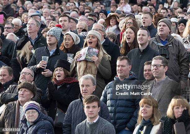 The crowd in grandstand and paddock cheer the horses running in first race during the 2016 Coral Welsh Grand National at Chepstow Racecourse on...