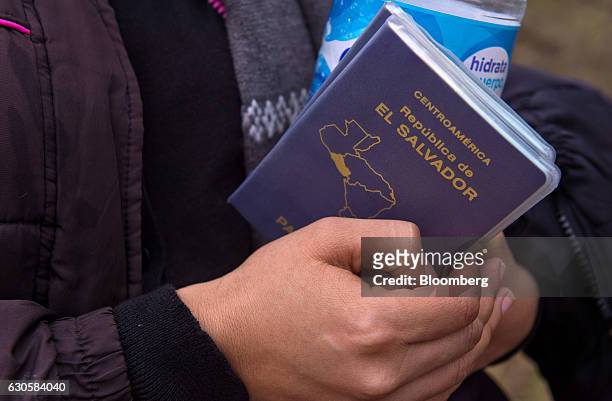 Suspected immigrant holds a passport from El Salvador after being detained by the U.S. Border Patrol near the U.S.-Mexico border in McAllen, Texas,...