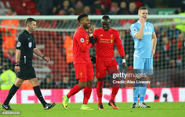 Ryan Shawcross of Stoke City looks dejected as Daniel Sturridge of Liverpool celebrates with team mates Sadio Mane as he scores their fourth goal...