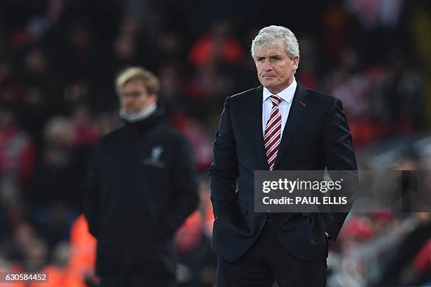 Liverpool's German manager Jurgen Klopp and Stoke City's Welsh manager Mark Hughes stand on the touchline during the English Premier League football...