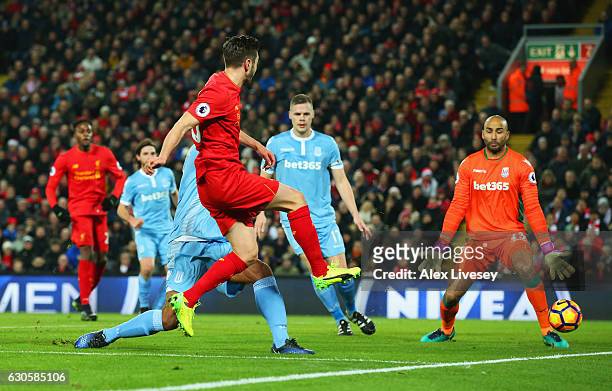 Adam Lallana of Liverpool shoots past Lee Grant of Stoke City to score their first goal during the Premier League match between Liverpool and Stoke...