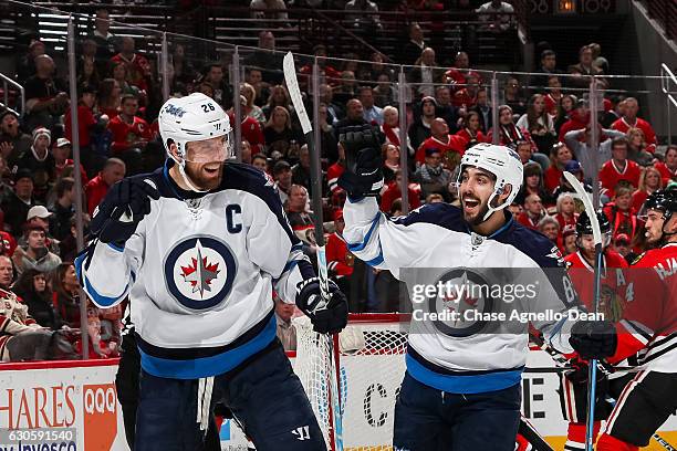 Blake Wheeler and Mathieu Perreault of the Winnipeg Jets celebrate after Wheeler scored against the Chicago Blackhawks in the first period at the...