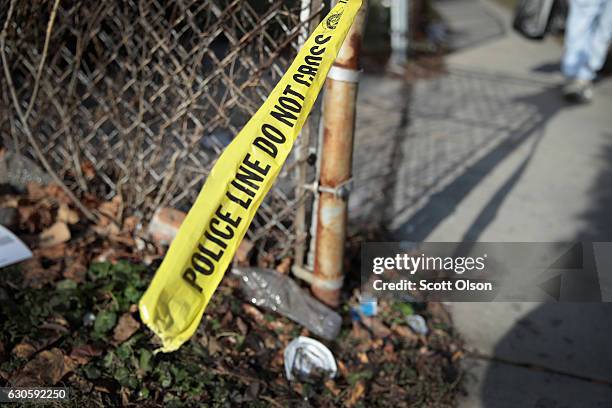 Crime scene tape clings to a fence where a Christmas Eve shooting left Derrick Jones and Stephen Tucker dead on December 27, 2016 in Chicago,...