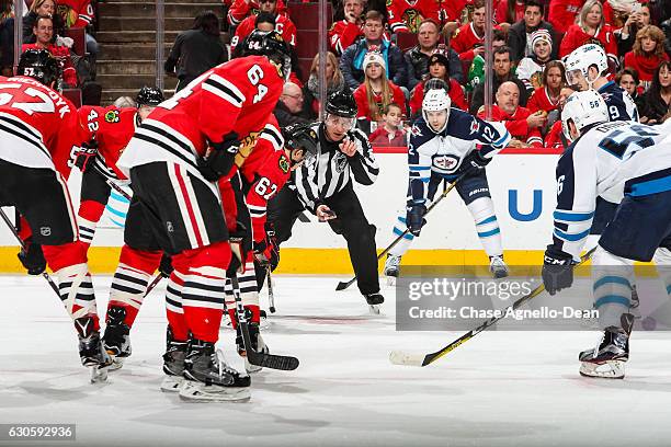 Linesman Devin Berg prepares to drop the puck for the face-off between the Chicago Blackhawks and the Winnipeg Jets in the first period at the United...