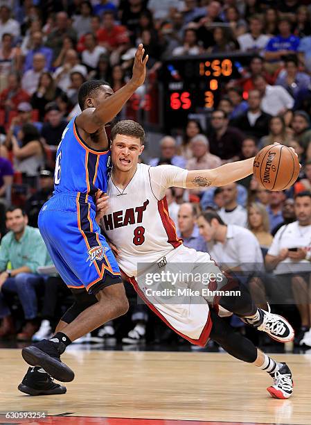 Tyler Johnson of the Miami Heat drives on Semaj Christon of the Oklahoma City Thunder during a game at American Airlines Arena on December 27, 2016...